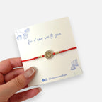Pulsera de hilo rojo Hv Hermanas Villegas con dije de San Benito en acero dorado y circones brillantes
