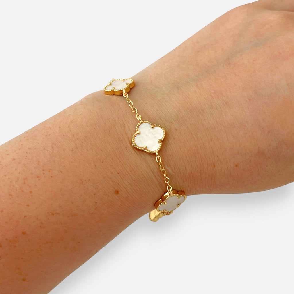 Pulsera Hv Hermanas Villegas de acero dorado con dijes de tréboles de cuatro hojas y efecto nácar blanco