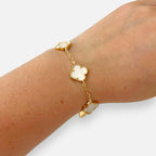 Pulsera Hv Hermanas Villegas de acero dorado con dijes de tréboles de cuatro hojas y efecto nácar blanco
