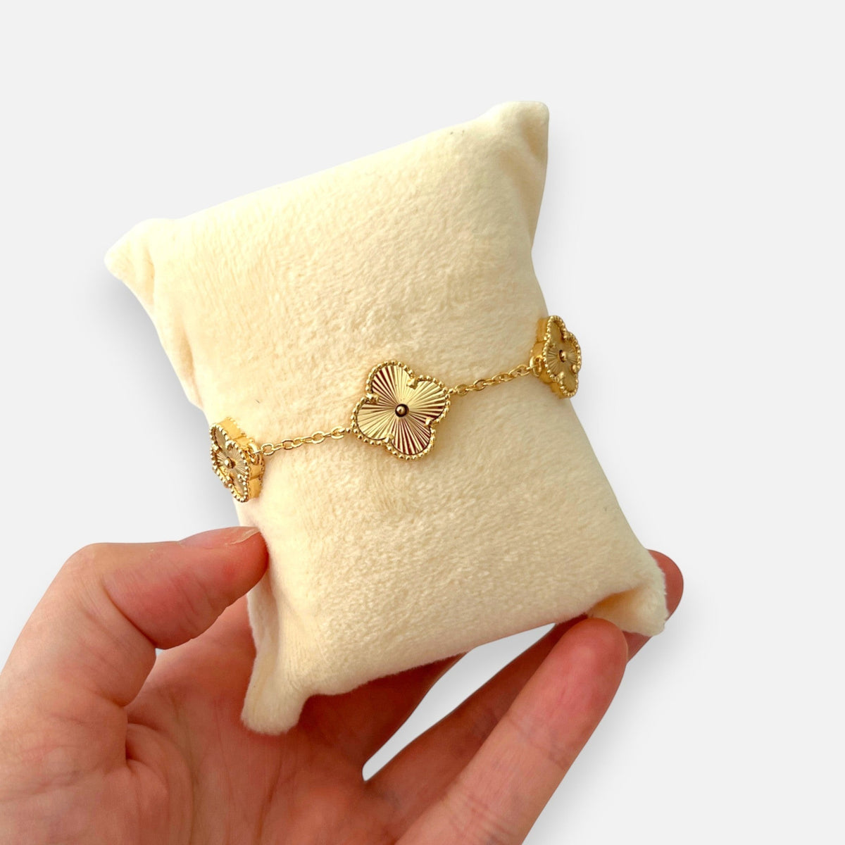 Pulsera Hv Hermanas Villegas de acero dorado con cinco dijes de trébol texturizados y borde perlado