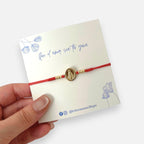 Pulsera Hv Hermanas Villegas de hilo rojo ajustable con medalla ovalada de la Virgen Milagrosa en acero dorado