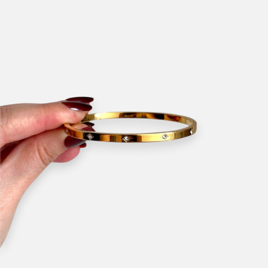 Puñera rígida Hv Hermanas Villegas de acero inoxidable dorado con circonitas incrustadas en diseño plano