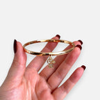 Pulsera rígida Hv Hermanas Villegas en oro rosé con dije de niño decorado con brillantes circonitas