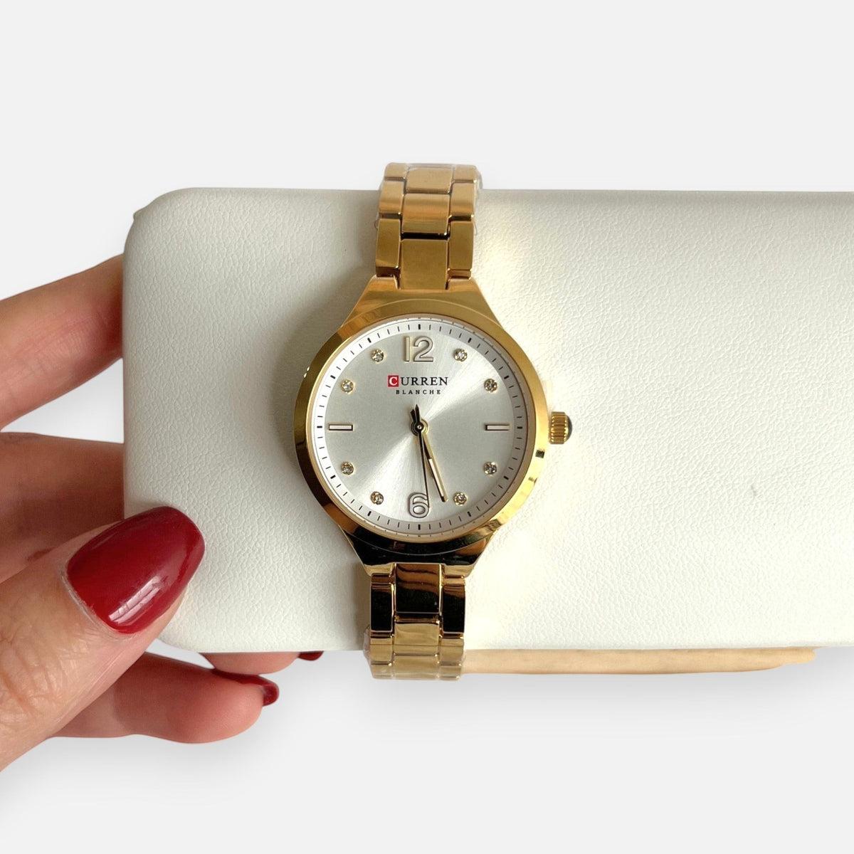 Reloj Hv Hermanas Villegas redondo en acero dorado con dial satinado, números aplicados y detalles de circones