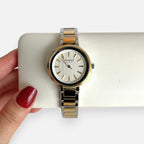 Reloj analógico Hv Hermanas Villegas bicolor con caja redonda, dial blanco texturizado y correa de acero articulada.