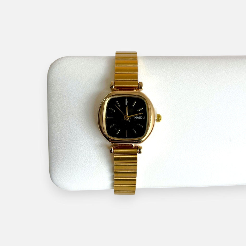 Reloj Hv Hermanas Villegas con caja cuadrada dorada, dial negro y correa extensible de acero estilo vintage