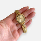 Reloj Hv Hermanas Villegas de acero dorado con caja cuadrada, dial champaña y correa de eslabones estilo vintage