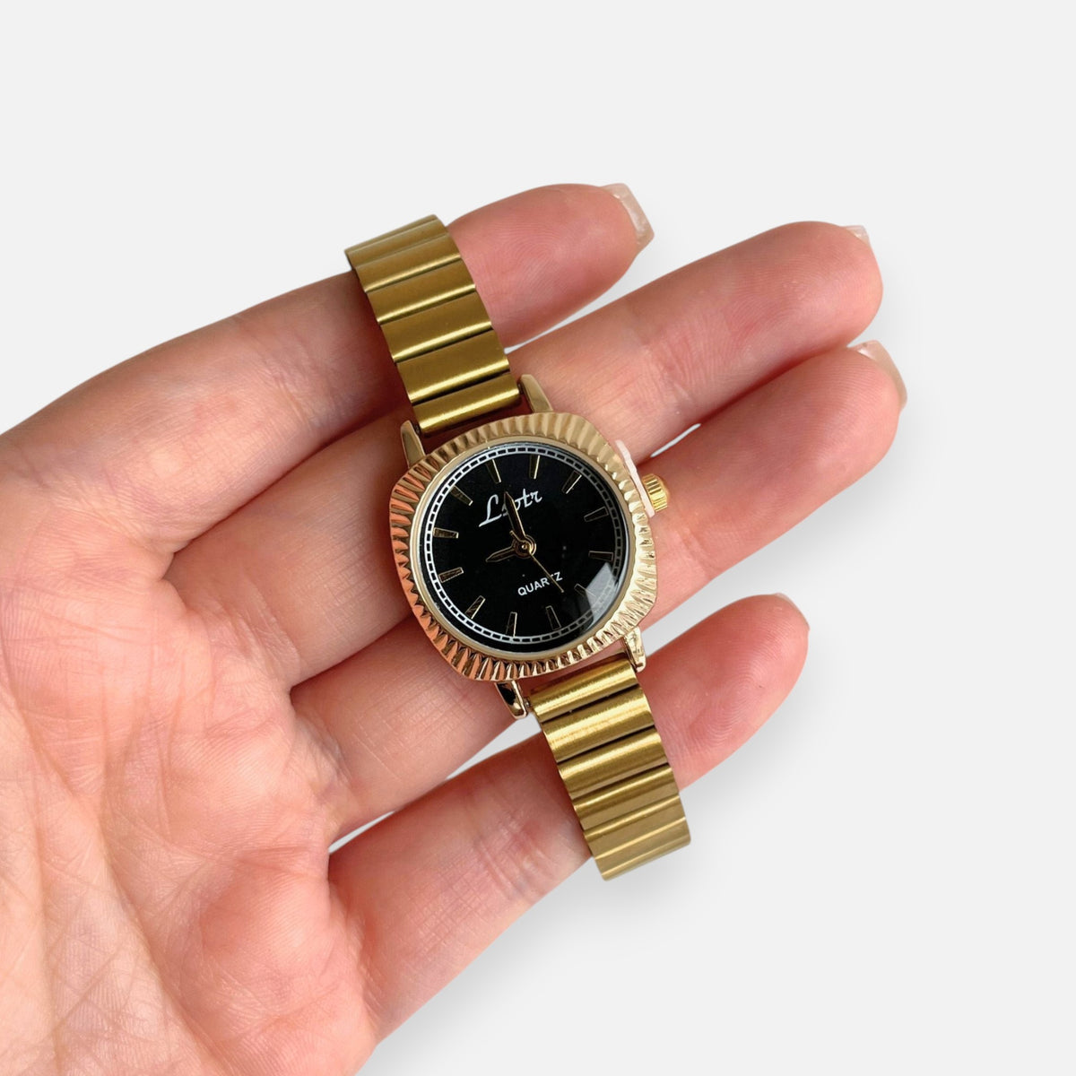Reloj Hv Hermanas Villegas de caja cuadrada dorada, correa de eslabones y dial negro con indicadores de hora dorados.