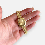 Reloj Hv Hermanas Villegas de acero dorado con caja cuadrada, dial satinado y correa de eslabones estilo vintage.