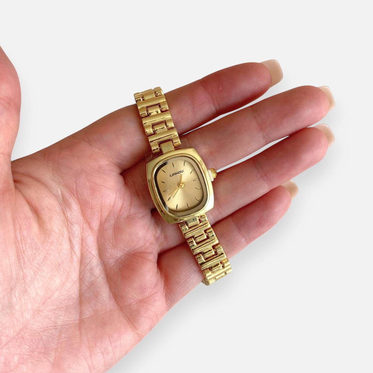 Reloj Hv Hermanas Villegas de acero dorado con caja cuadrada, dial satinado y correa de eslabones estilo vintage.
