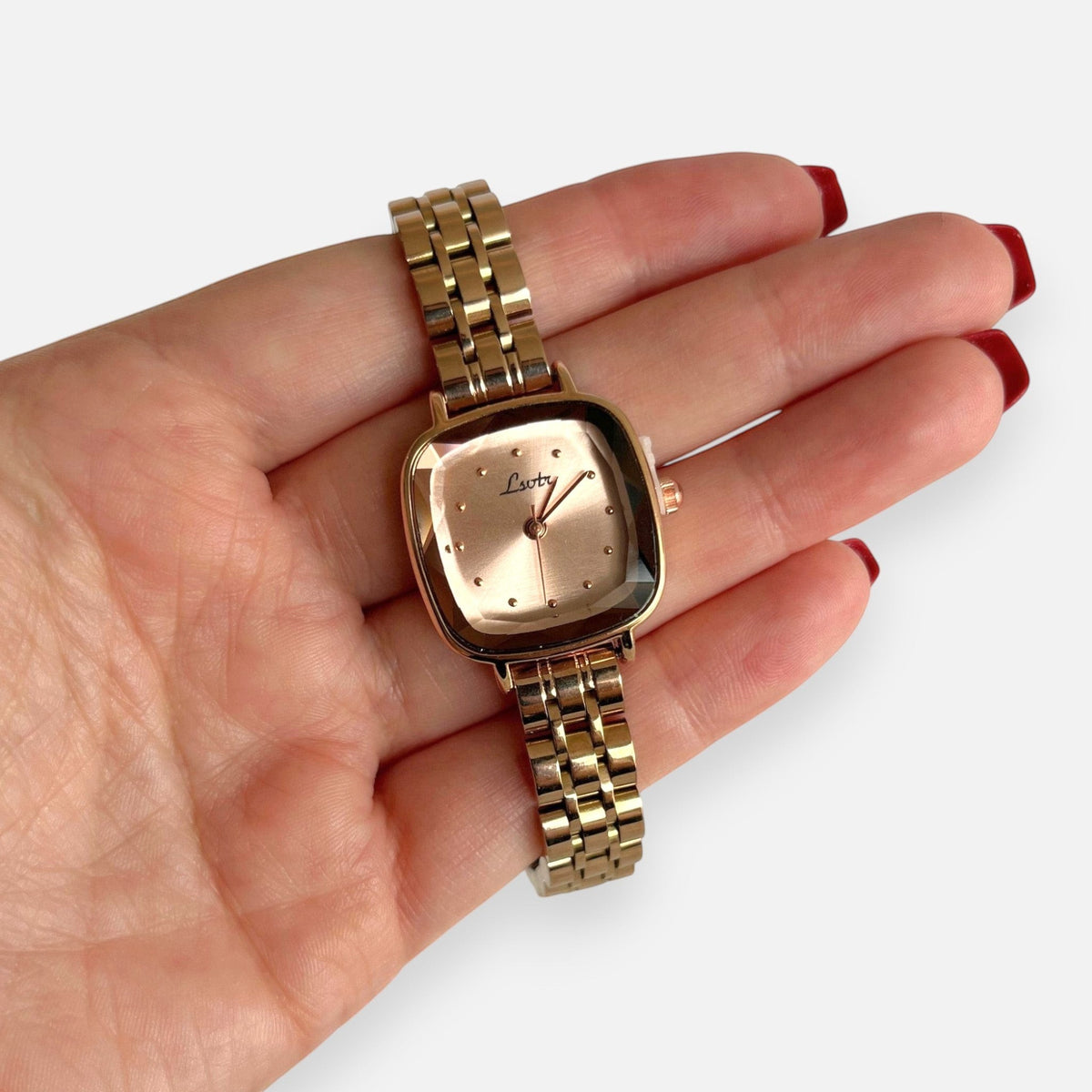 Reloj Hv Hermanas Villegas de acero oro rosa con caja cuadrada, dial satinado y correa de eslabones finos en mano