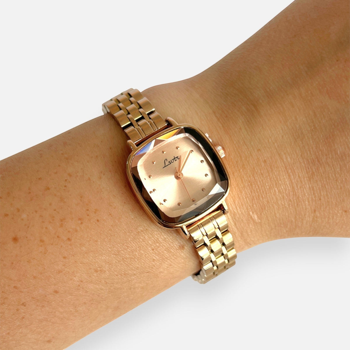 Reloj Hv Hermanas Villegas de acero en oro rosa con caja cuadrada y correa de eslabones finos en una muñeca