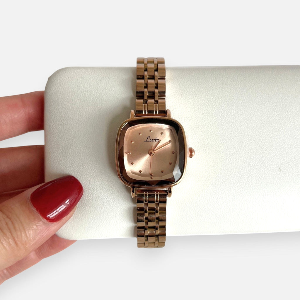 Reloj Hv Hermanas Villegas de acero en oro rosa con caja cuadrada, dial satinado y correa de eslabones finos.
