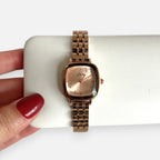 Reloj Hv Hermanas Villegas de acero en oro rosa con caja cuadrada, dial satinado y correa de eslabones finos.