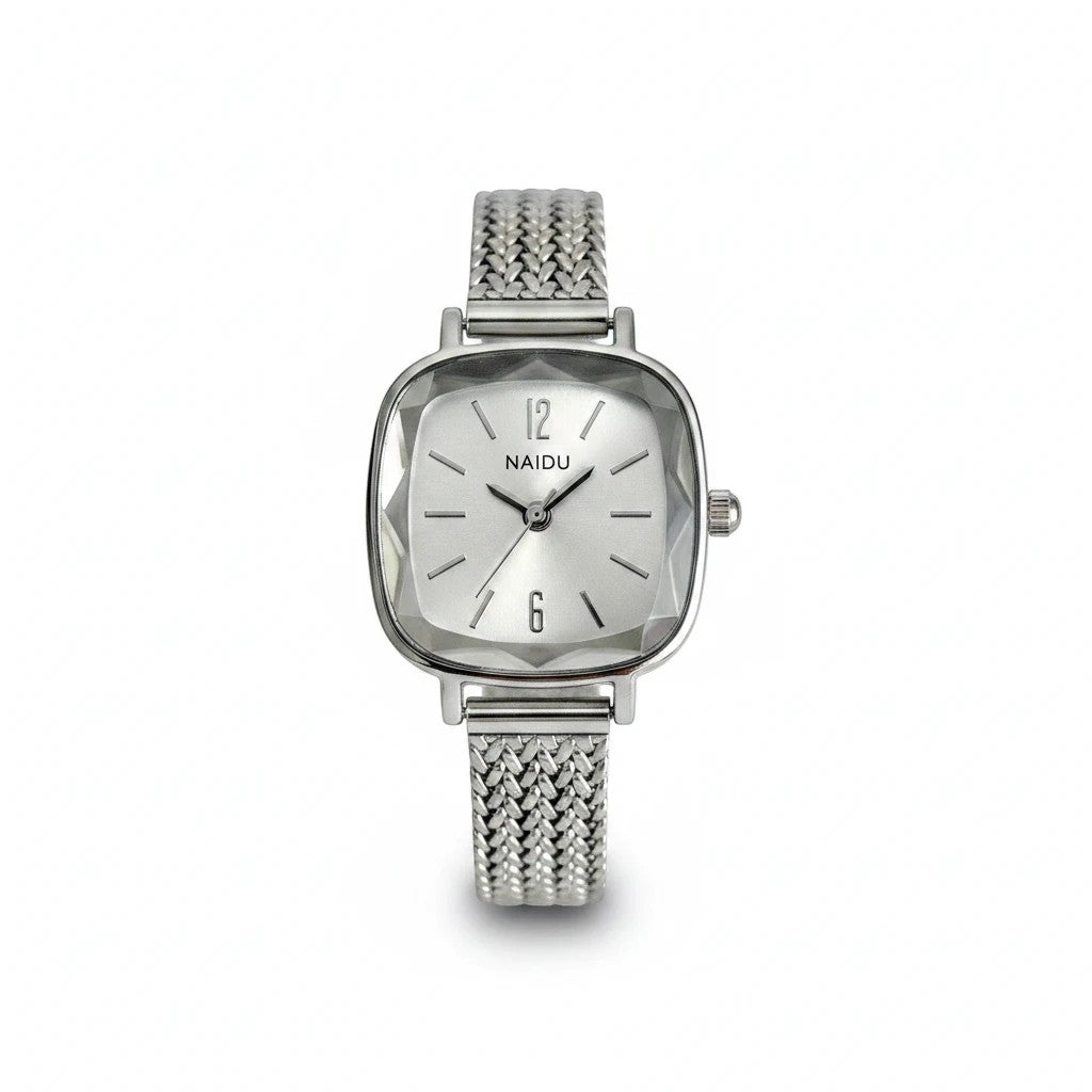 Reloj analógico Hv Hermanas Villegas con caja cuadrada plateada, bisel labrado y correa de acero trenzada vintage.