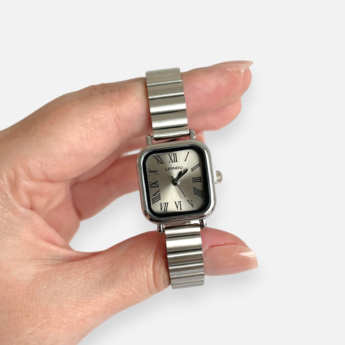 Reloj Hv Hermanas Villegas de acero plateado con caja cuadrada, dial champán y números romanos estilo vintage.