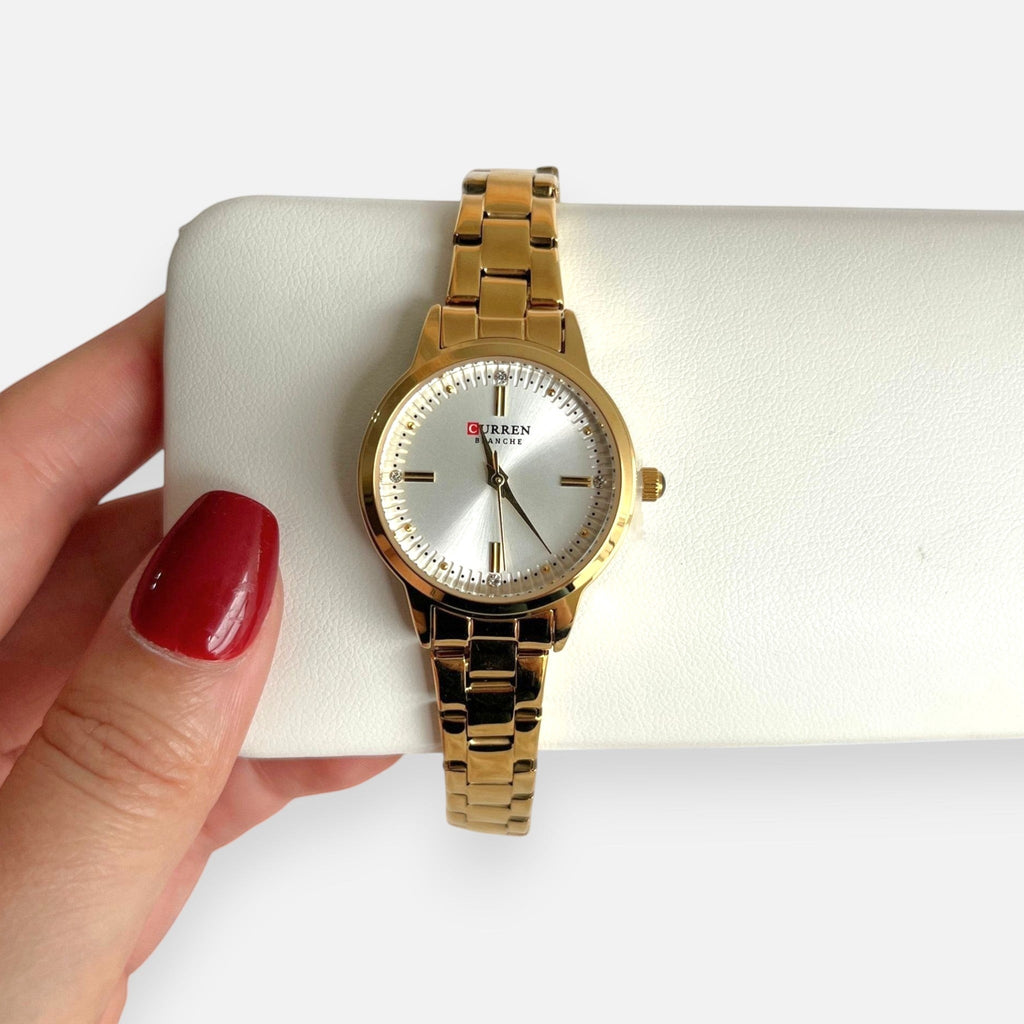 Reloj Hv Hermanas Villegas dorado de acero con dial satinado y circones, diseño analógico elegante y sofisticado.
