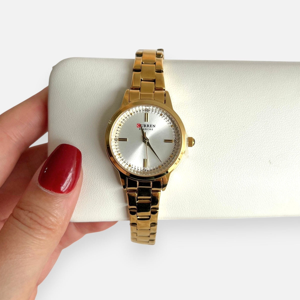 Reloj Hv Hermanas Villegas dorado de acero con dial satinado y circones, diseño analógico elegante y sofisticado.