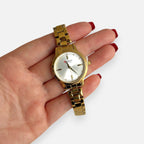 Reloj analógico Hv Hermanas Villegas dorado con correa de acero, dial satinado y detalles de circones en la mano