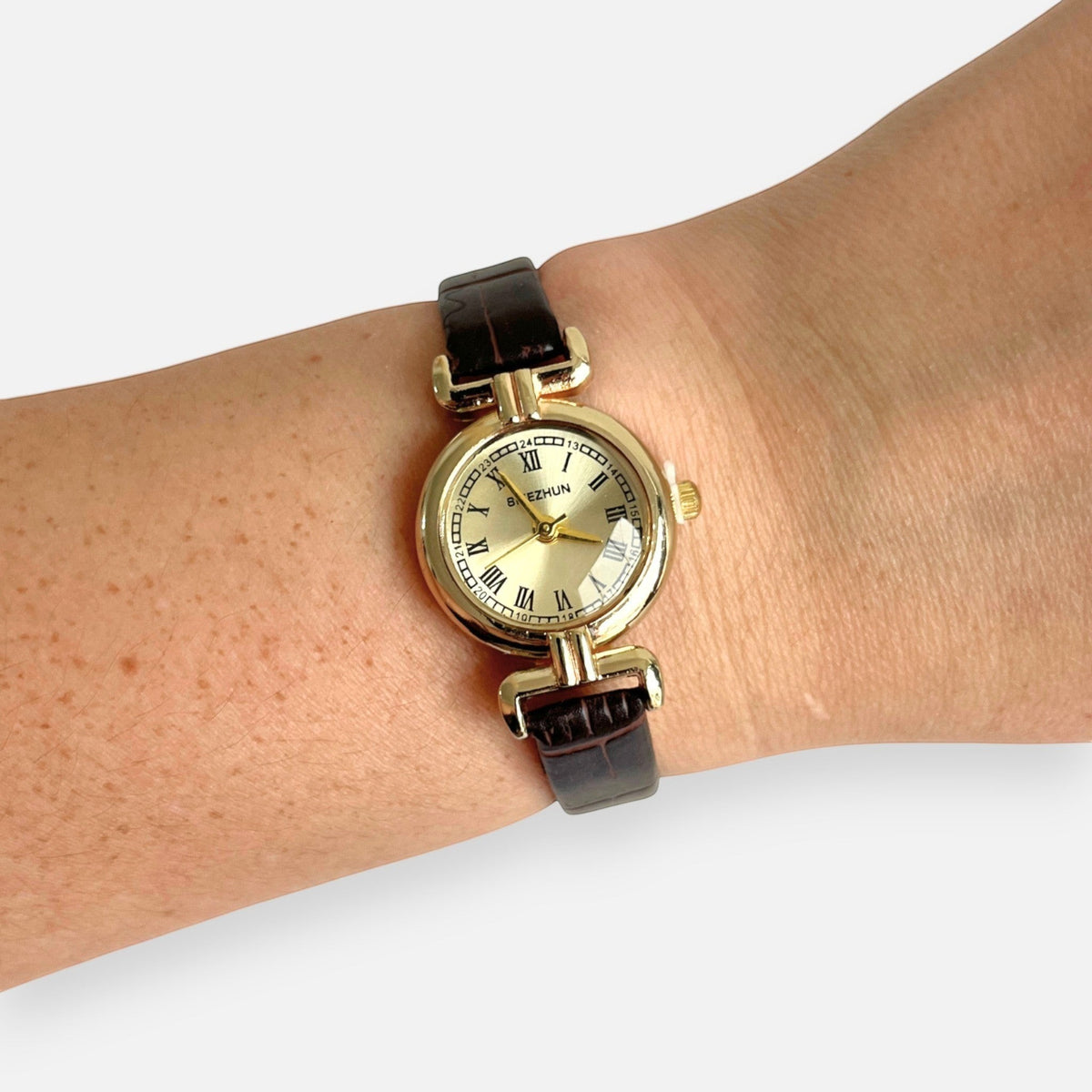 Reloj Hv Hermanas Villegas con caja redonda dorada, dial champán y correa de cuero vegano marrón estilo vintage