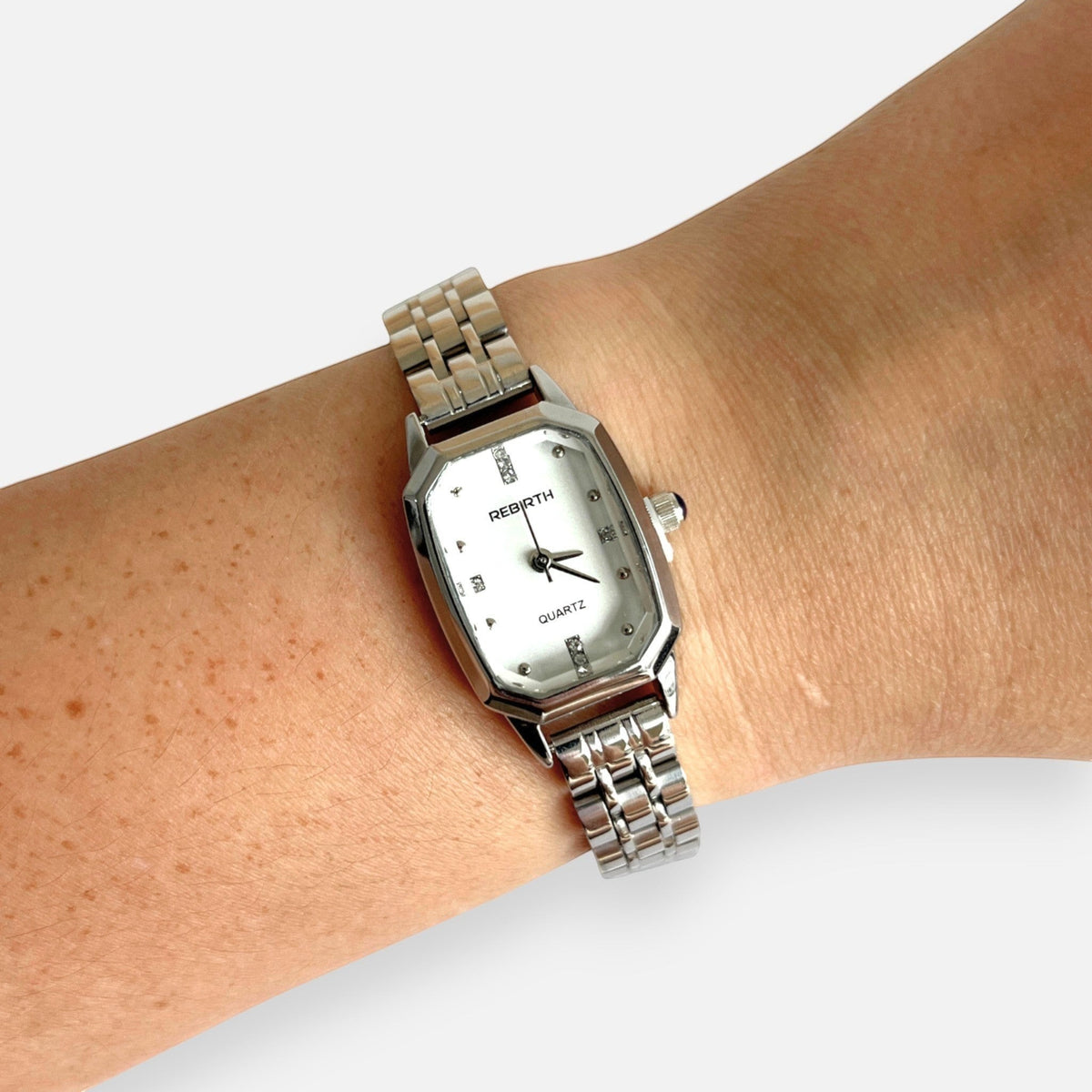 Reloj Hv Hermanas Villegas octagonal plateado con correa de eslabones y dial brillante en muñeca