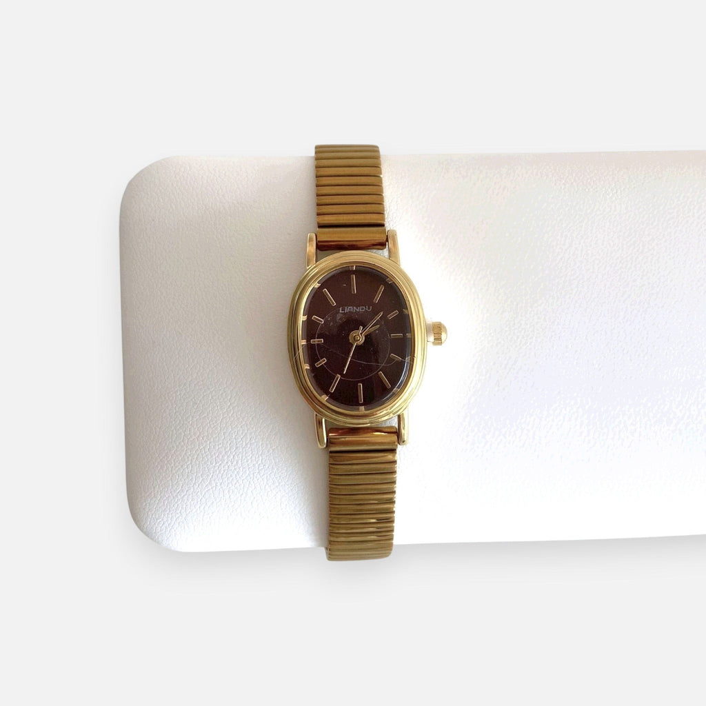 Reloj Hv Hermanas Villegas ovalado dorado con dial guinda y correa metálica extensible de estilo vintage