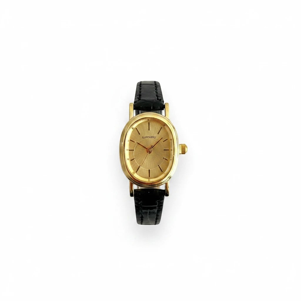 Reloj Hv Hermanas Villegas con caja ovalada dorada, dial cepillado y correa de cuero vegano negro estilo vintage.