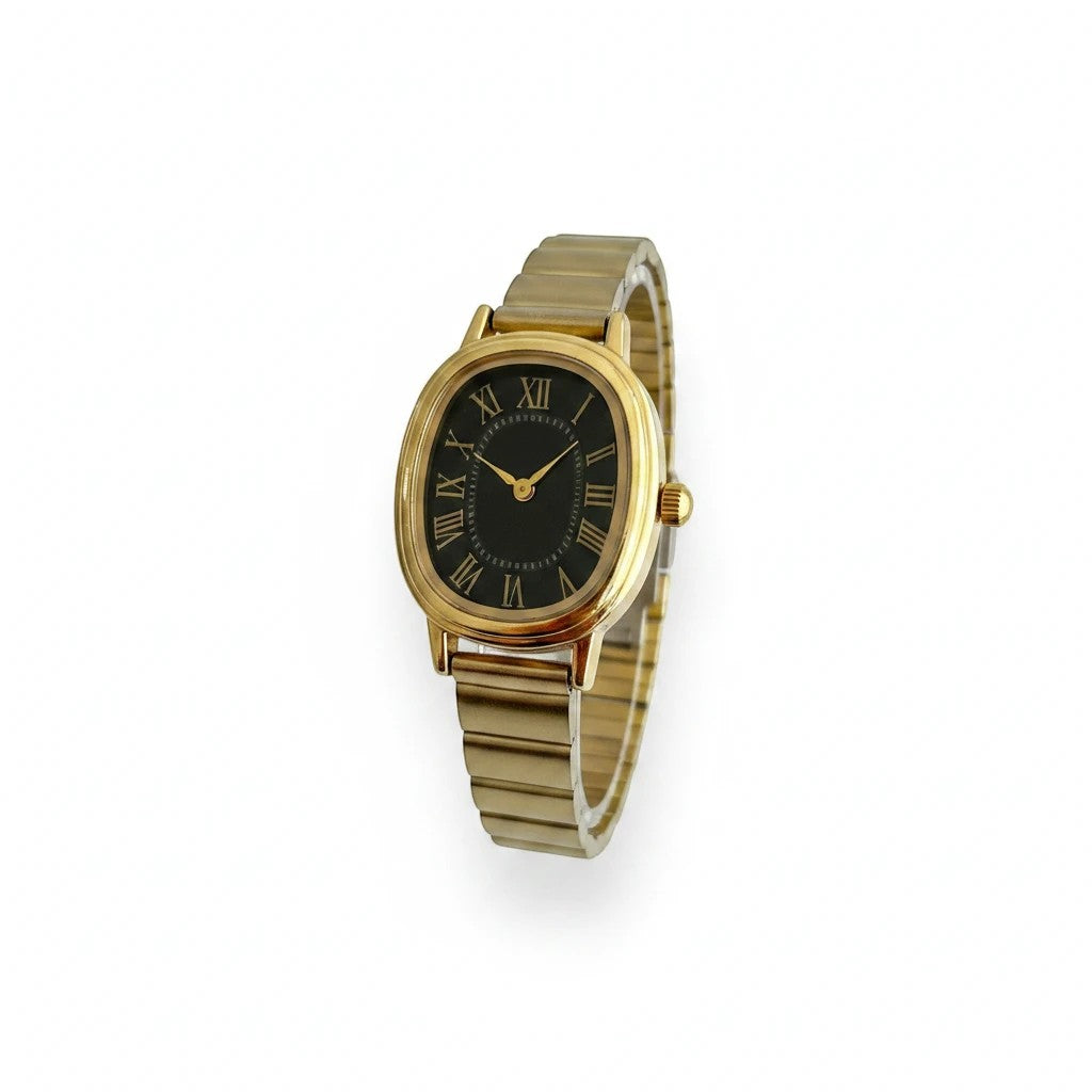 Reloj Hv Hermanas Villegas ovalado con caja dorada, dial negro y números romanos en correa de acero extensible.