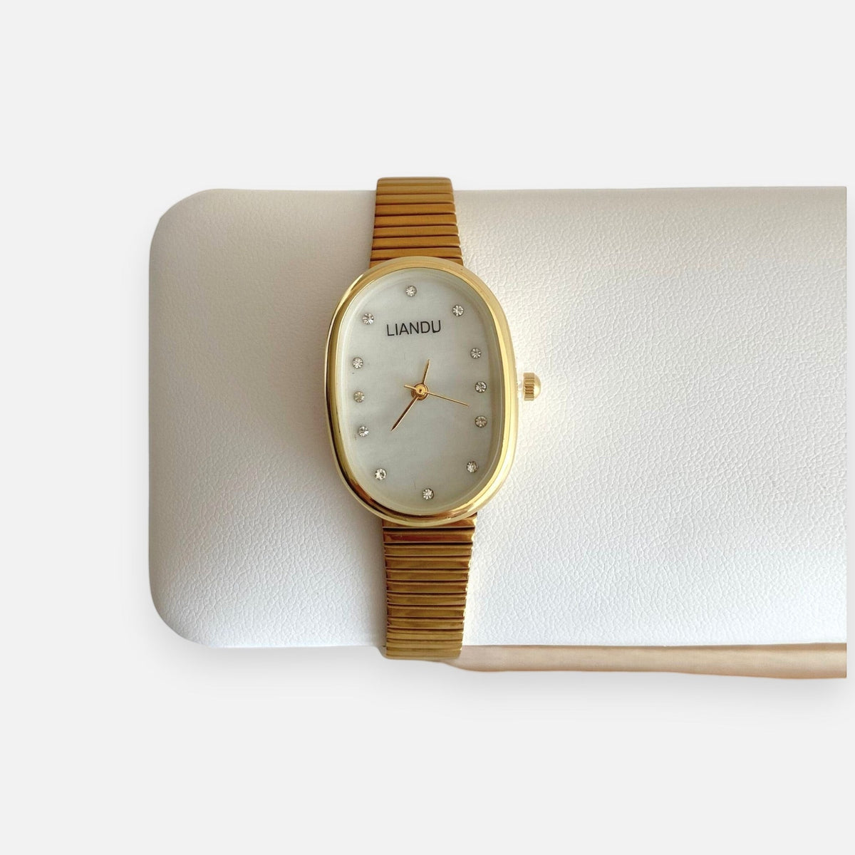 Reloj Hv Hermanas Villegas ovalado dorado con dial nacarado, marcadores de cristales y correa extensible flexible