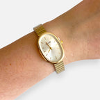 Reloj Hv Hermanas Villegas ovalado en acero dorado con correa de eslabones flexibles y dial minimalista en muñeca