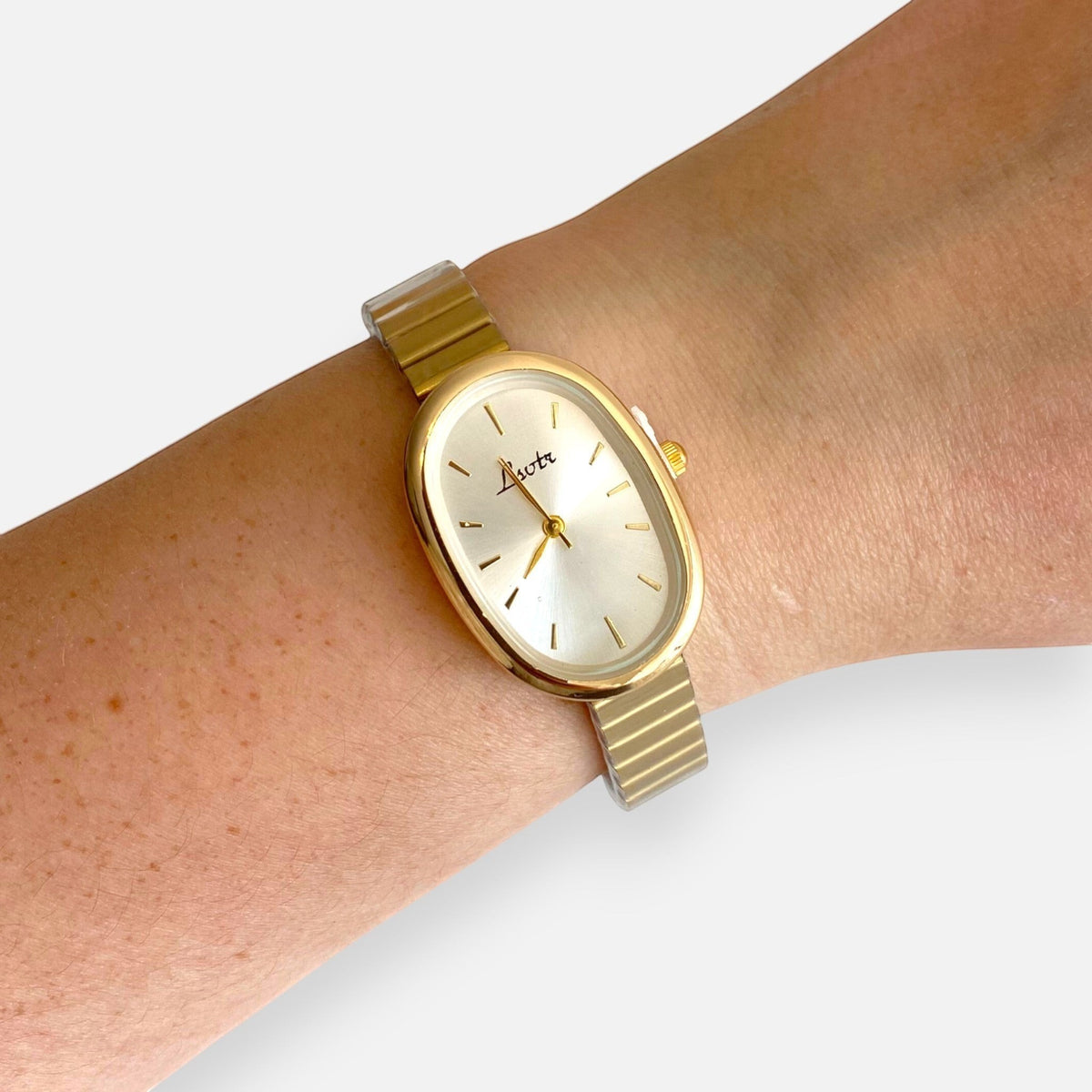 Reloj Hv Hermanas Villegas ovalado en acero dorado con correa de eslabones flexibles y dial minimalista en muñeca