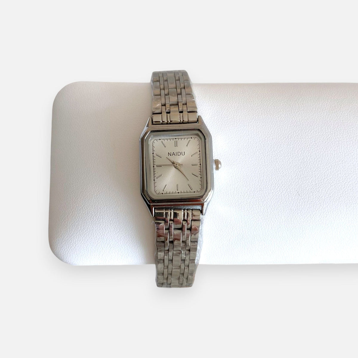 Reloj analógico Hv Hermanas Villegas de acero plateado con caja rectangular, dial satinado y correa de eslabones.