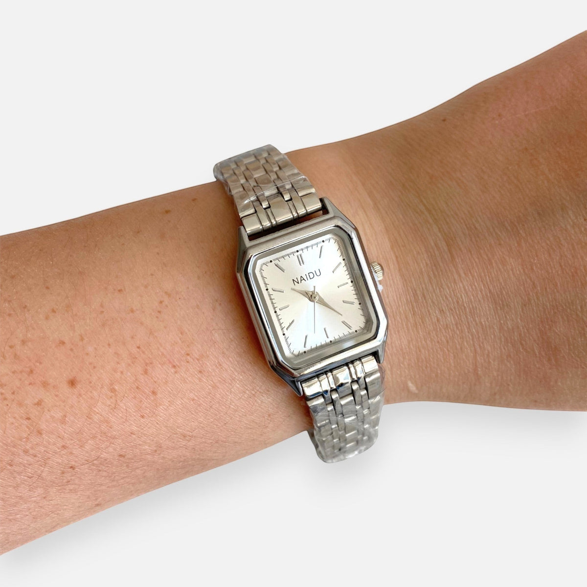 Reloj analógico Hv Hermanas Villegas de acero plateado con caja rectangular y dial minimalista en muñeca femenina