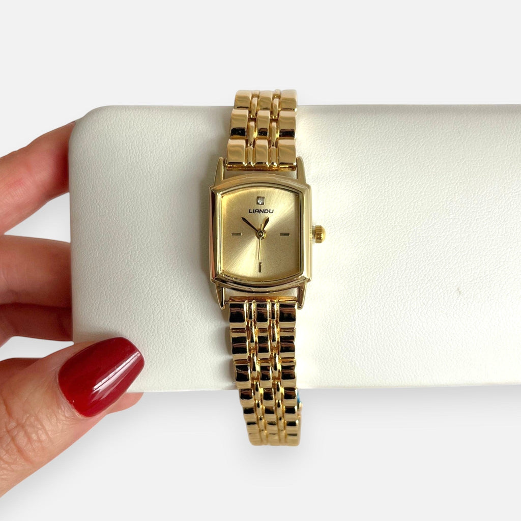 Reloj Hv Hermanas Villegas rectangular dorado de acero con dial satinado, circon en las 12 y correa de eslabones.
