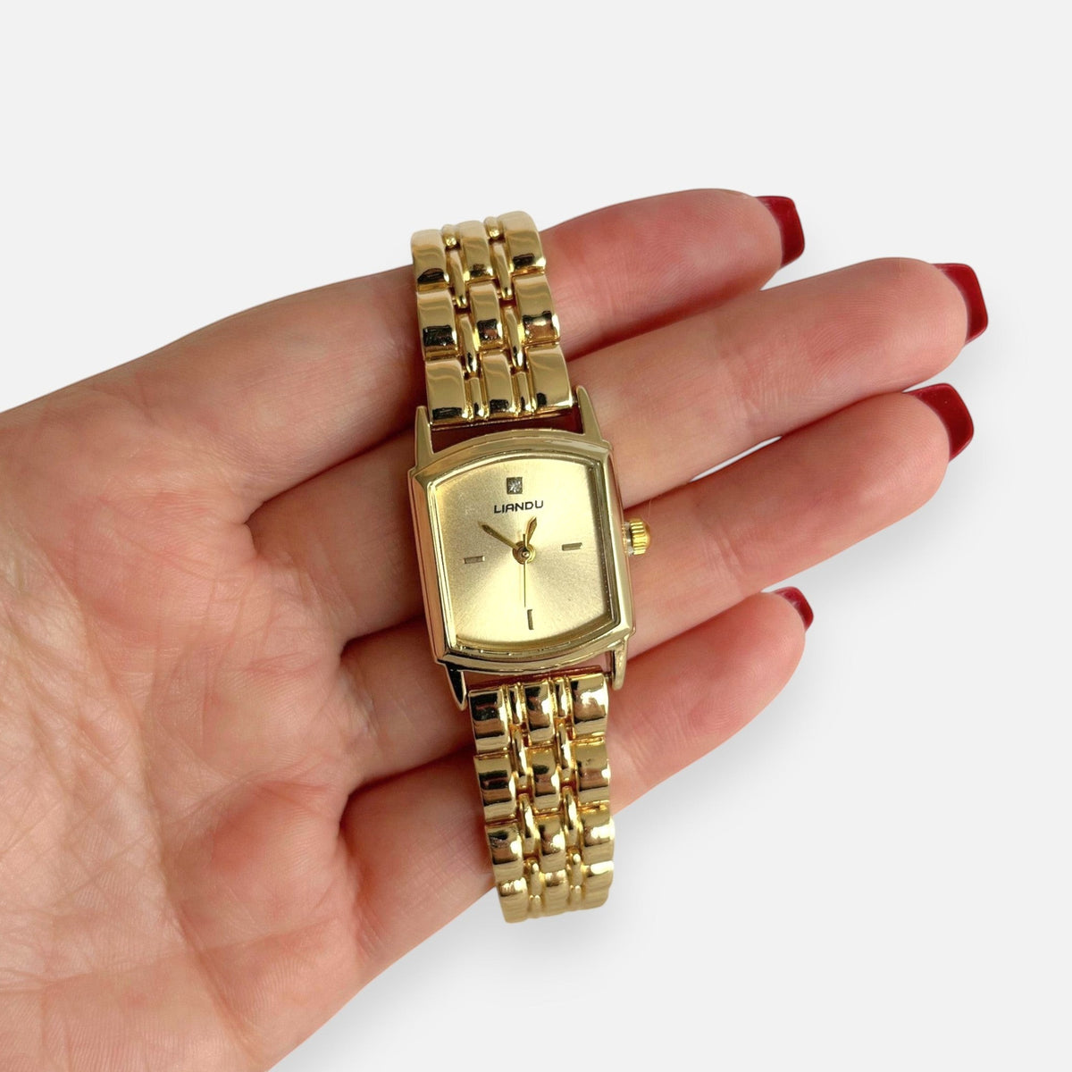 Reloj Hv Hermanas Villegas rectangular dorado de acero con dial satinado y circon en la posición de las 12