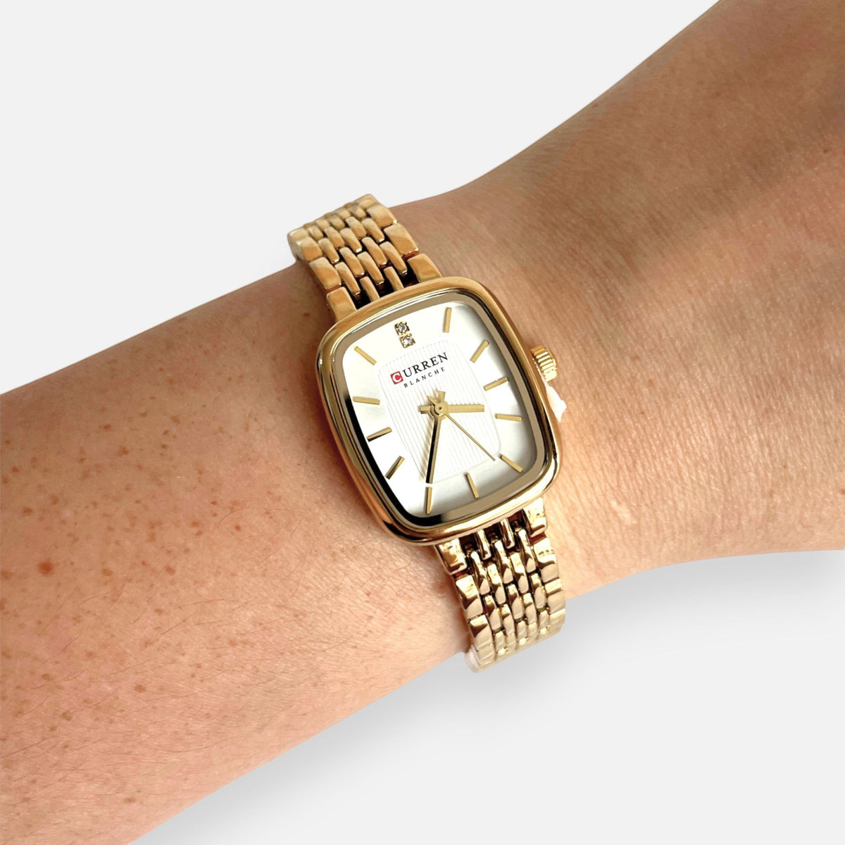Reloj Hv Hermanas Villegas rectangular dorado con correa de eslabones y dial claro con detalle brillante