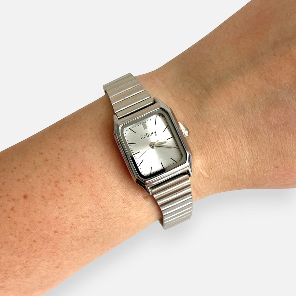 Reloj Hv Hermanas Villegas rectangular plateado con correa extensible y dial minimalista en muñeca